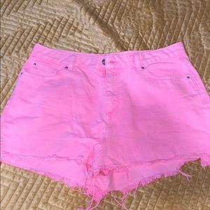 Neon pink distressed denim shorts